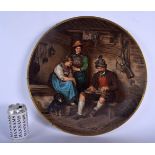 A LARGE ANTIQUE VIENNA PORCELAIN CHARGER painted with figures and a hound within an interior. 40 cm