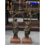 A VERY LARGE PAIR OF 19TH CENTURY FRENCH BRONZE AND MARBLE CANDLESTICKS modelled holding aloft cornu