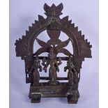 AN 18TH CENTURY INDIAN HINDU BUDDHISTIC BRONZE SHRINE modelled standing in front of a floral plate.