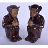 A PAIR OF CHINESE QING DYNASTY TREACLE GLAZED POTTERY FIGURES modelled as monkey clutching fruit. 18