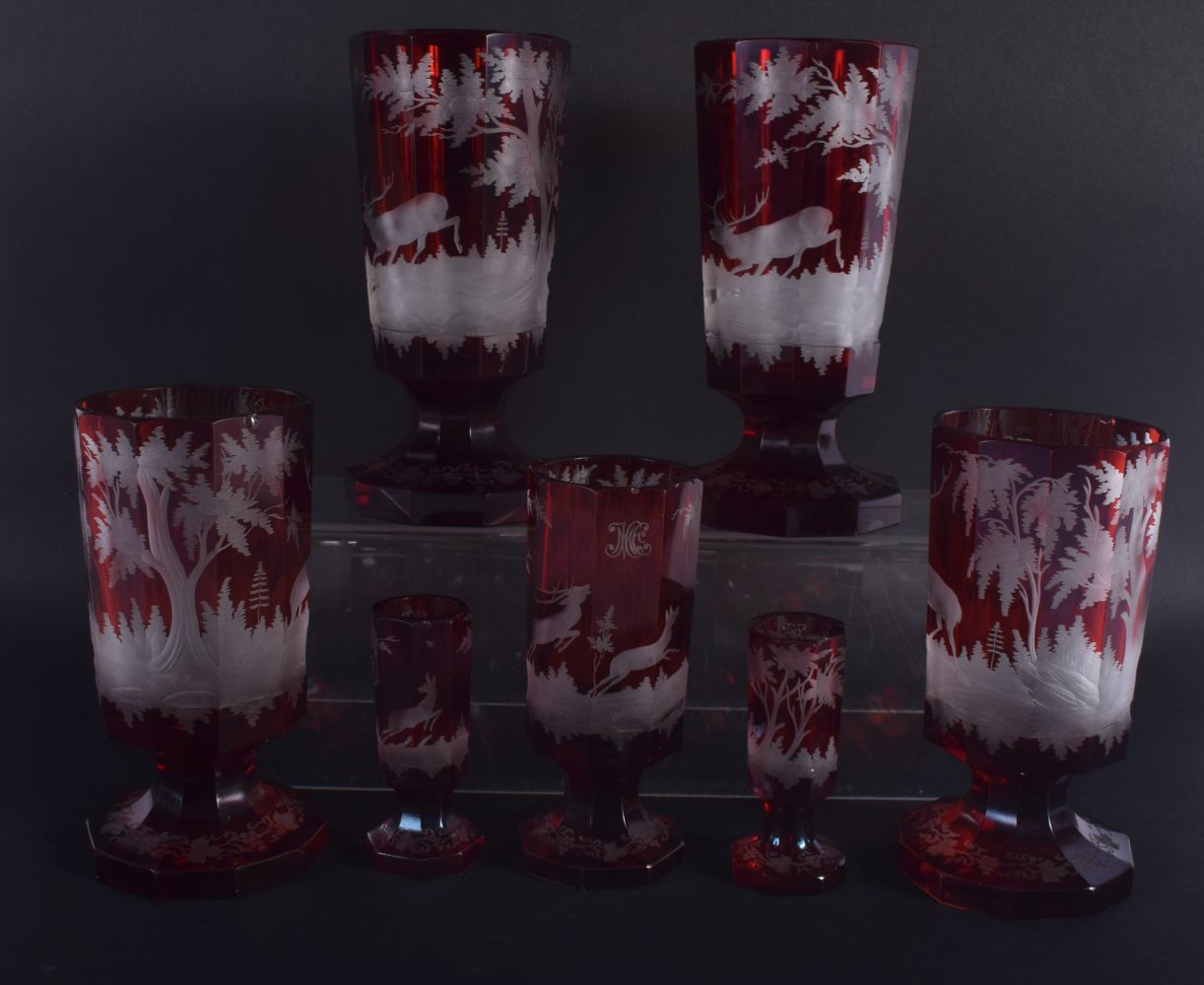 SEVEN ANTIQUE BOHEMIAN RUBY GLASS GOBLET BEAKERS decorated with deer. Largest 18.5 cm high. (7) - Image 2 of 2