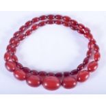 AN ART DECO CHERRY AMBER TYPE NECKLACE. 55 grams. 66 cm long, largest bead 3 cm x 2 cm.