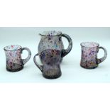 A coloured crackle glass jug and three beakers. 16cm (4).