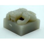 A FINE 19TH CENTURY CHINESE CARVED GREENISH WHITE JADE SEAL Qing modelled as a stylised dragon upon