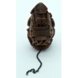 AN 18TH/19TH CENTURY FRENCH CARVED COQUILLA NUT SNUFF BOTTLE decorated with dogs, guns and swords. 6