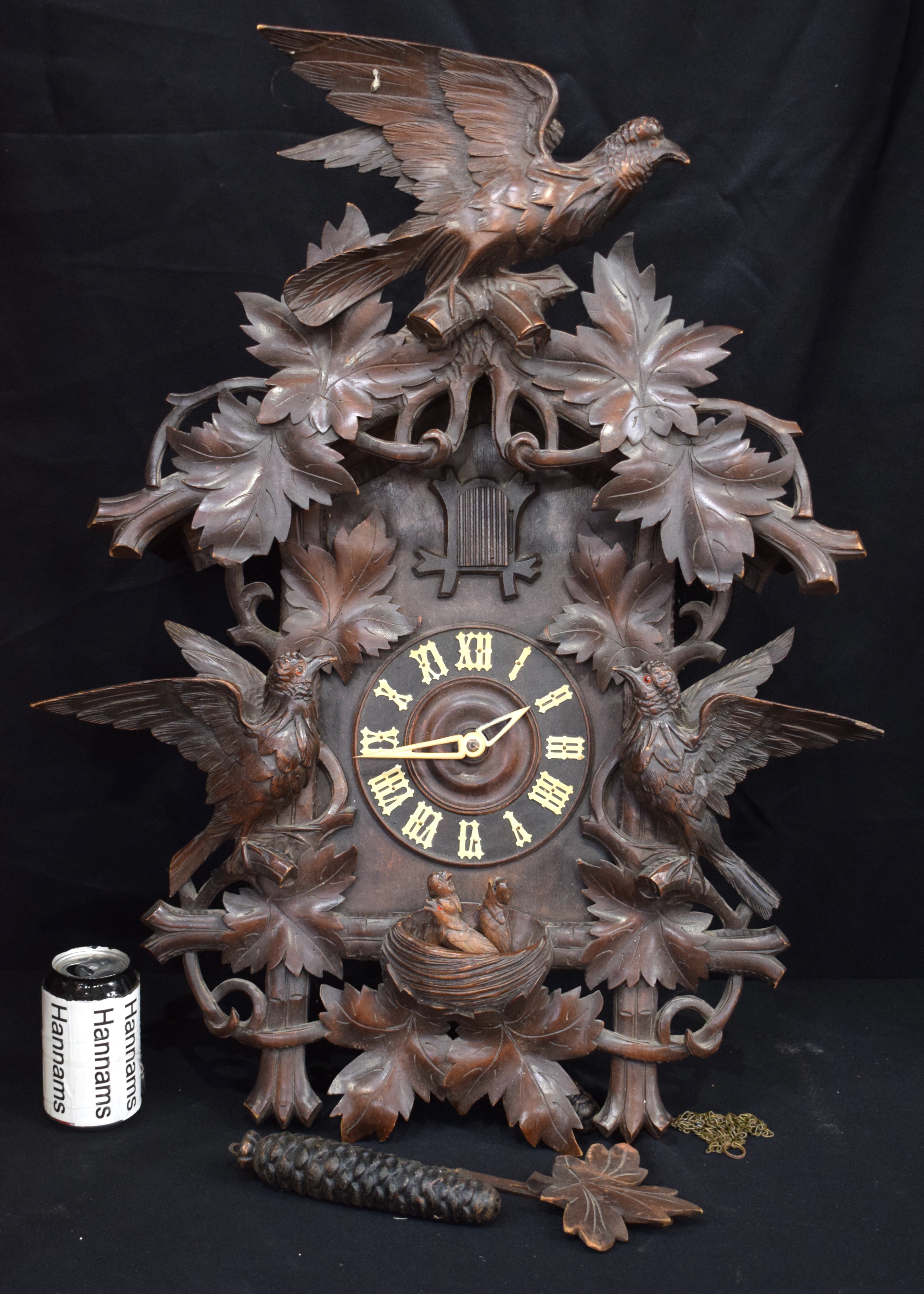 A 19TH CENTURY BAVARIAN BLACK FOREST CARVED WOOD CUCKOO CLOCK formed with opposing birds beside a ne