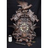 A 19TH CENTURY BAVARIAN BLACK FOREST CARVED WOOD CUCKOO CLOCK formed with opposing birds beside a ne