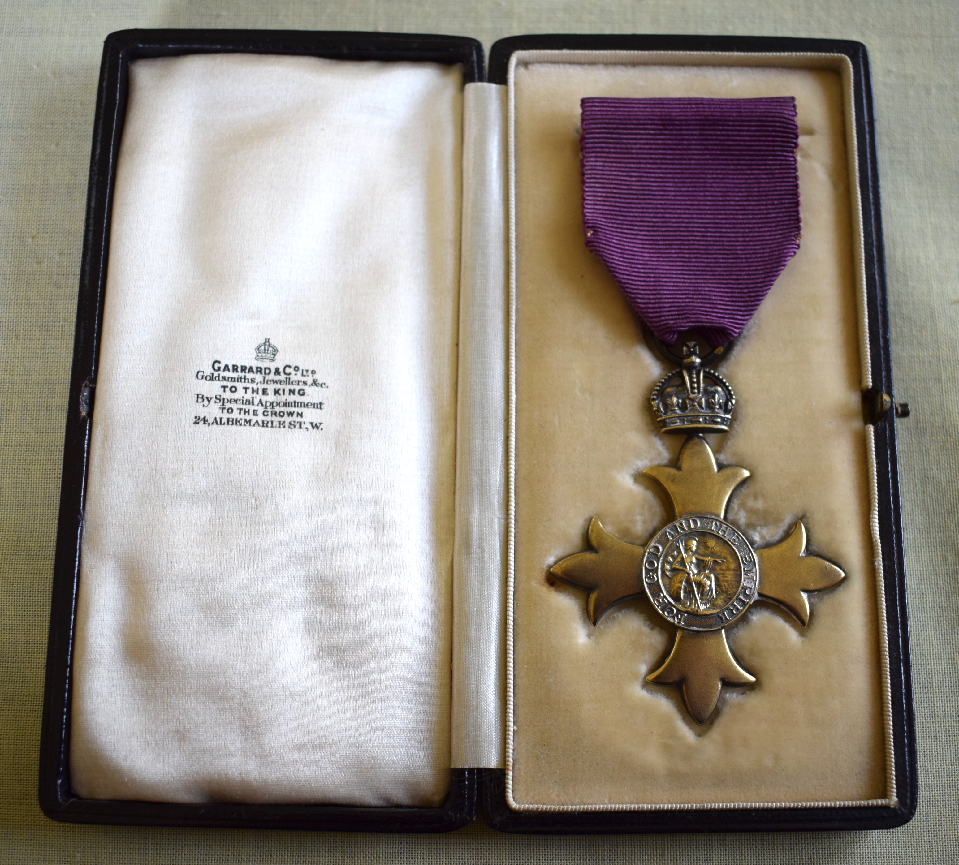 A GEORGE V SILVER GILT CASED OBE MEDAL in original fitted case. Medal 6.5 cm x 4.5 cm.
