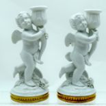 A PAIR OF PORTUGUESE VISTA ALLEGRE PORCELAIN CANDLESTICKS modelled as cherubs holding sconces. 21 cm