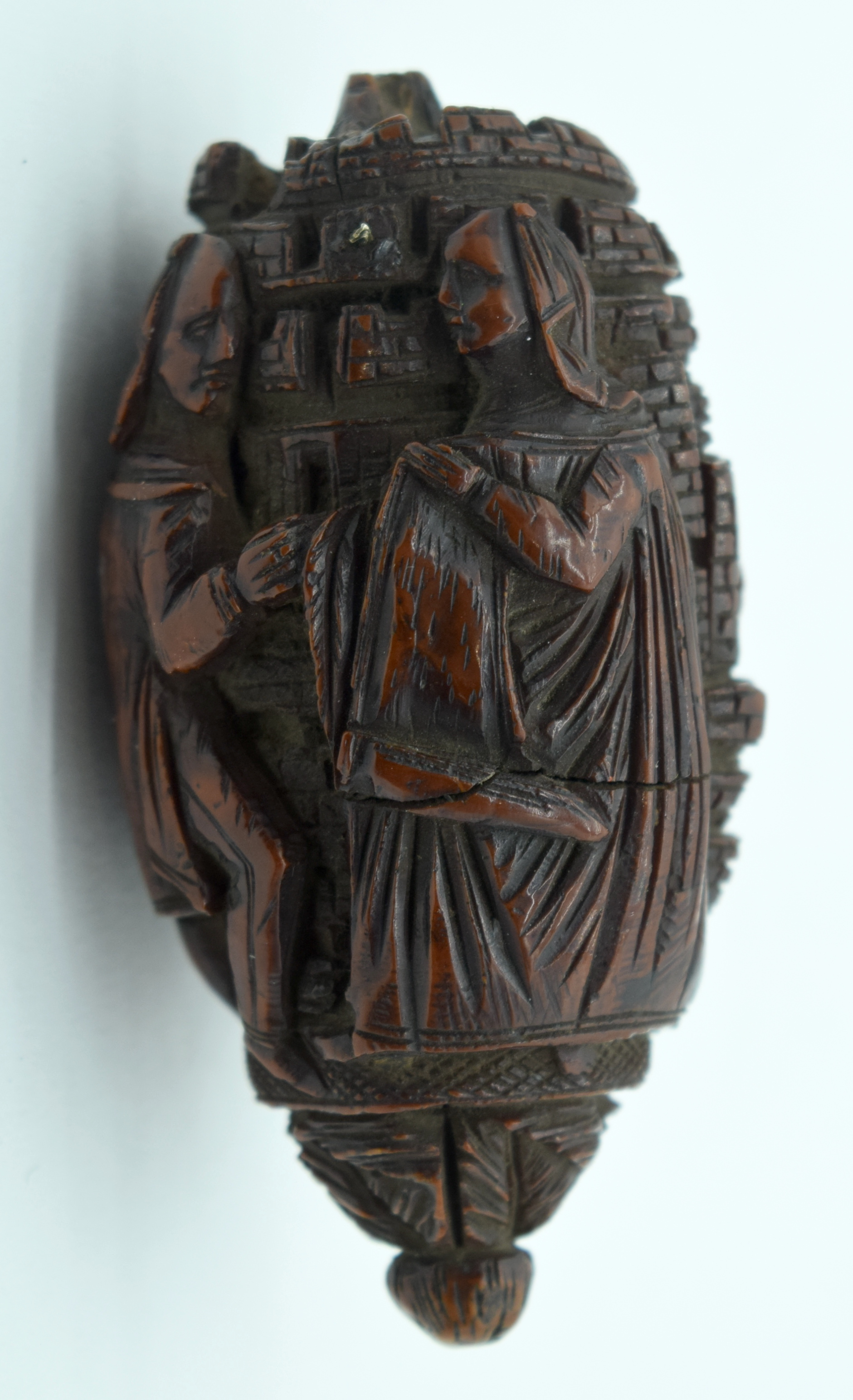 AN 18TH/19TH CENTURY FRENCH CARVED COQUILLA NUT SNUFF BOTTLE formed with figures in various pursuits