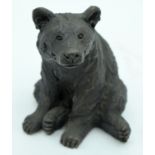 A CONTEMPORARY BRONZED FIGURE OF A BEAR modelled resting upon his front paws. 16 cm x 10 cm.