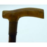 A 19TH CENTURY MIDDLE EASTERN CARVED RHINOCEROS HORN HANDLED SWAGGER STICK. 80 cm long.