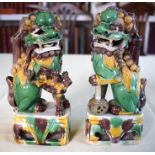 A PAIR OF 17TH CENTURY CHINESE EGG AND SPINACH GLAZED BUDDHISTIC LIONS modelled upon similarly decor