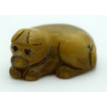 A RARE 19TH CENTURY CHINESE CARVED RHINOCEROS HORN FIGURE OF A DOG modelled recumbent. 7 grams. 2.5