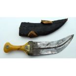 AN EARLY 20TH CENTURY MIDDLE EASTERN OMANI AMBER HANDLED JAMBIYA DAGGER inset with yellow metal coin
