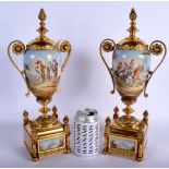 A PAIR OF LATE 19TH CENTURY FRENCH GILT METAL AND ENAMEL TWIN HANDLED VASES painted with cavaliers w