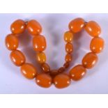 AN EARLY 20TH CENTURY AMBER BAKELITE CATALIN NECKLACE. 96 grams. 46 cm long, largest bead 2.75 cm x
