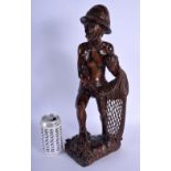 A 1950S SOUTH EAST ASIAN CARVED WOOD FIGURE OF A STANDING FISHERMAN modelled upon a rocky outcrop. 4