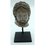 A carved head of a Persian male on a stand 10cm (2).