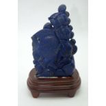 A carved Lapis Lazuli boulder on a wooden stand depicting fish.18 x 10cm (2).