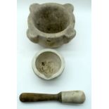 An antique stone pestle and mortar set (3) 13 x 21cm .