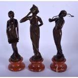 A SET OF THREE CONTEMPORARY BRONZE FIGURES upon red marble bases. 23.5 cm high. (3)