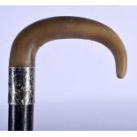 A 19TH CENTURY MIDDLE EASTERN CARVED RHINOCEROS HORN HANDLED CANE with ebonised shaft. 85 cm long.