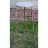 AN INDUSTRIAL COPPER ALLOY WOOD STOOL with tapering legs. 70 cm x 28 cm.