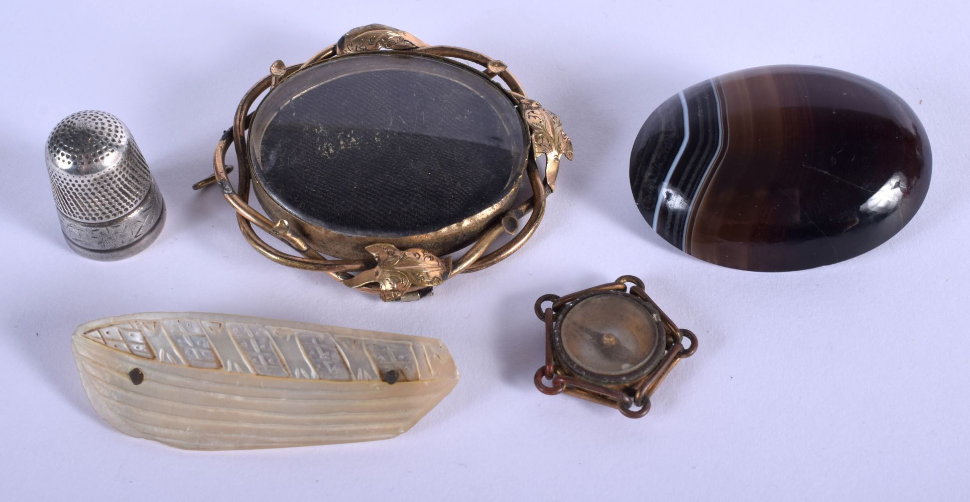 AN ANTIQUE CARVED AGATE BROOCH together with a yellow metal brooch etc. (5)