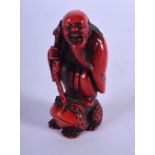 A RARE 19TH CENTURY JAPANESE RED LACQUERED IVORY NETSUKE modelled as a scholar upon a toad. 5 cm x 2