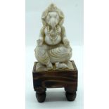 A carved alabaster figure of Ganesh on a stand 18cm .