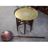 AN ISLAMIC BRASS TOPPED FOLDING TABLE and a copper warming pan. (2)