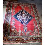 A LARGE MIDDLE EASTERN RED GROUND CARPET decorated with a blue lozenge of flowers. 354 cm x 264 cm.