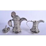 TWO EARLY 20TH CENTURY MIDDLE EASTERN WHITE METAL EWERS decorated with foliage. 707 grams. Largest 1