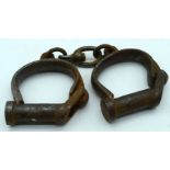 An antique pair of iron handcuffs 24cm.