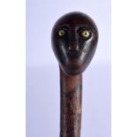 AN UNUSUAL 19TH CENTURY CONTINENTAL CARVED FRUITWOOD FOLK ART WALKING CANE with brass inlaid eyes. 8