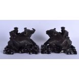 A PAIR OF 19TH CENTURY CHINESE CARVED HARDWOOD BUFFALOS modelled upon hardwood bases. 25 cm x 18 cm.