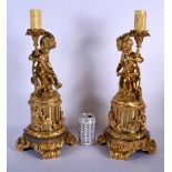 A LARGE PAIR OF 19TH CENTURY FRENCH BRONZE AND ORMOLU CANDLESTICKS formed as a putti holding aloft s