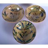 THREE PERSIAN ISLAMIC MIDDLE EASTERN POTTERY BOWLS painted with flowers. 25 cm x 14 cm. (3)