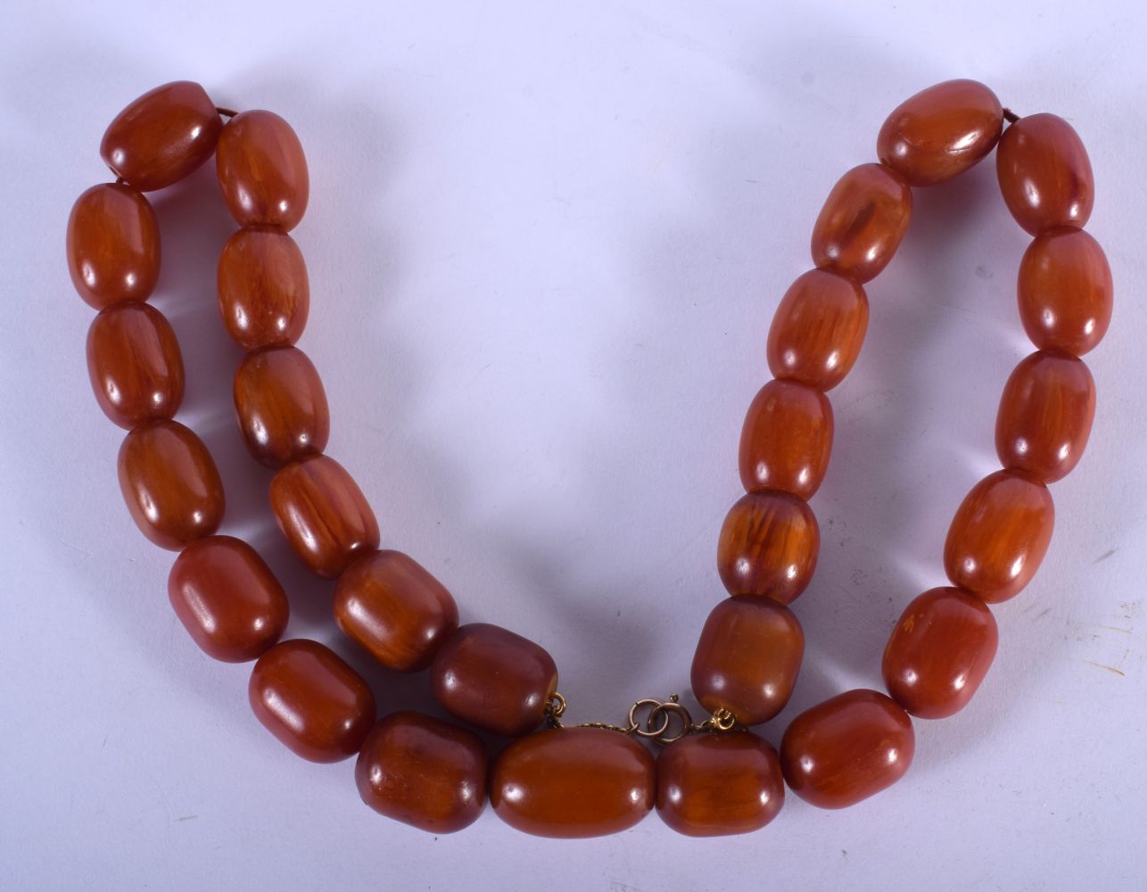 AN EARLY 20TH CENTURY AMBER BAKELITE CATALIN NECKLACE. 137 grams. 64 cm long, largest bead 2 cm x 1.