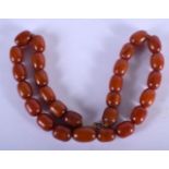 AN EARLY 20TH CENTURY AMBER BAKELITE CATALIN NECKLACE. 137 grams. 64 cm long, largest bead 2 cm x 1.