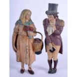 AN UNUSUAL PAIR OF COLD PAINTED LEAD FIGURES OF A DANDY AND FEMALE the male modelled covering his mo