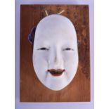 A VERY RARE EARLY 20TH CENTURY JAPANESE WHITE PAINTED POTTERY NOH MASK upon a plaque painted with ca