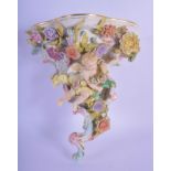 AN EARLY 20TH CENTURY GERMAN PORCELAIN ENCRUSTED WALL BRACKET formed as a cherub amongst vines. 22 c