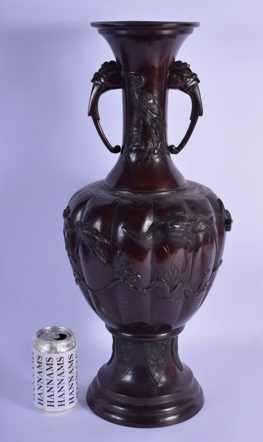 A LARGE 19TH CENTURY JAPANESE MEIJI PERIOD TWIN HANDLED BRONZE VASE decorated with foliage and vines