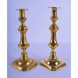 A LARGE NEAR PAIR OF LATE GEORGE III BRASS CANDLESTICKS upon square form bases. Largest 31 cm high.