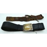 A leather belt with a collection of Military badges and buttons together with another vintage leath