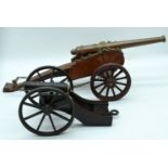 A large Mid century bronze and wood table cannon together with a smaller cannon 57cm (2).