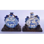 A PAIR OF 19TH CENTURY EUROPEAN FAIENCE TIN GLAZED POTTERY FLASKS painted with a roaming bull and de