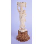 A 19TH CENTURY ANGLO INDIAN CARVED IVORY FIGURE OF A FRUIT CARRIER modelled upon a wood base. Ivory
